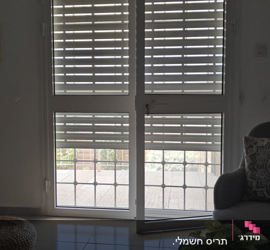 תריסי אלומיניום פתוחים על דלת זכוכית